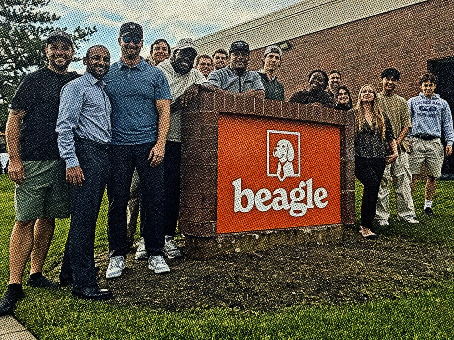 Halftone photograph of the Salt Lake City team gathered around the Beagle office sign